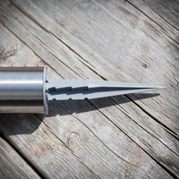 Jolo solar spike light lit at night in a garden casting a soft white glow beside decking