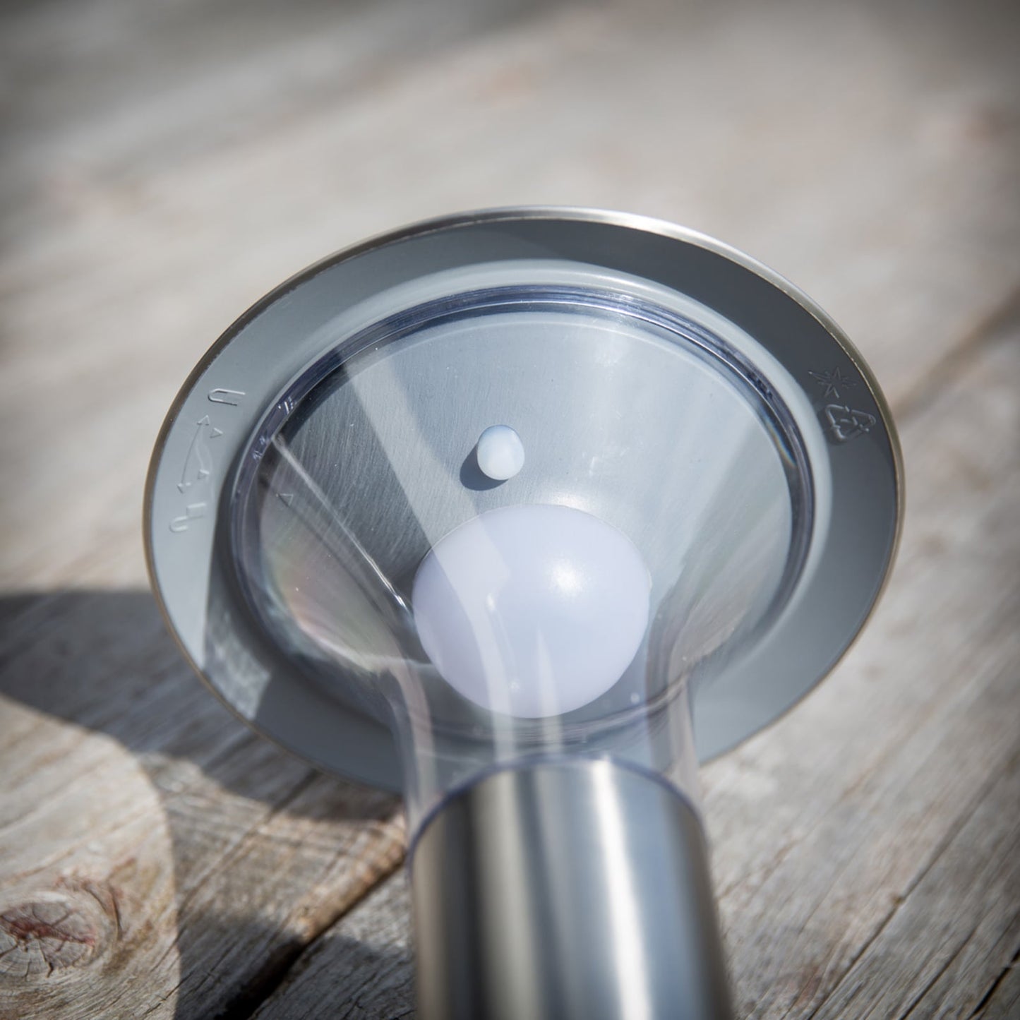 Close up of the integrated solar panel set into the stainless steel top disc of the Jolo solar spike light