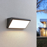 Abbo LED wall light switched on at dusk beside a modern house exterior