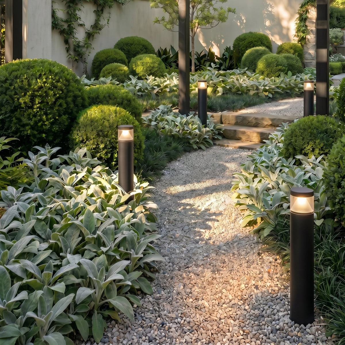 Darjo Tall Bollard Lights lining a gravel garden path at dusk