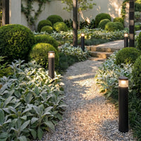 Darjo Tall Bollard Lights lining a gravel garden path at dusk