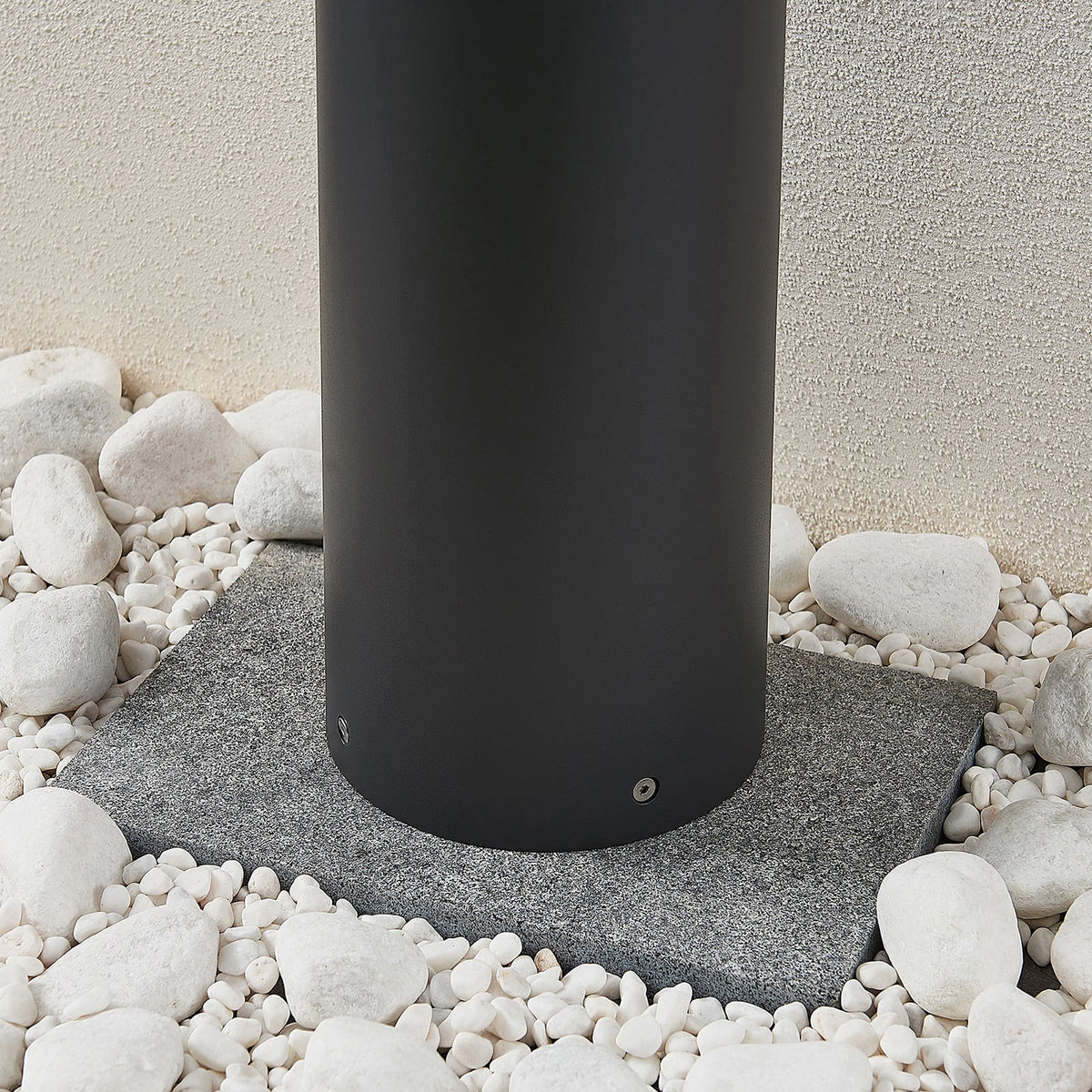 Base of the Darjo Tall Bollard Light set into a bed of white pebbles