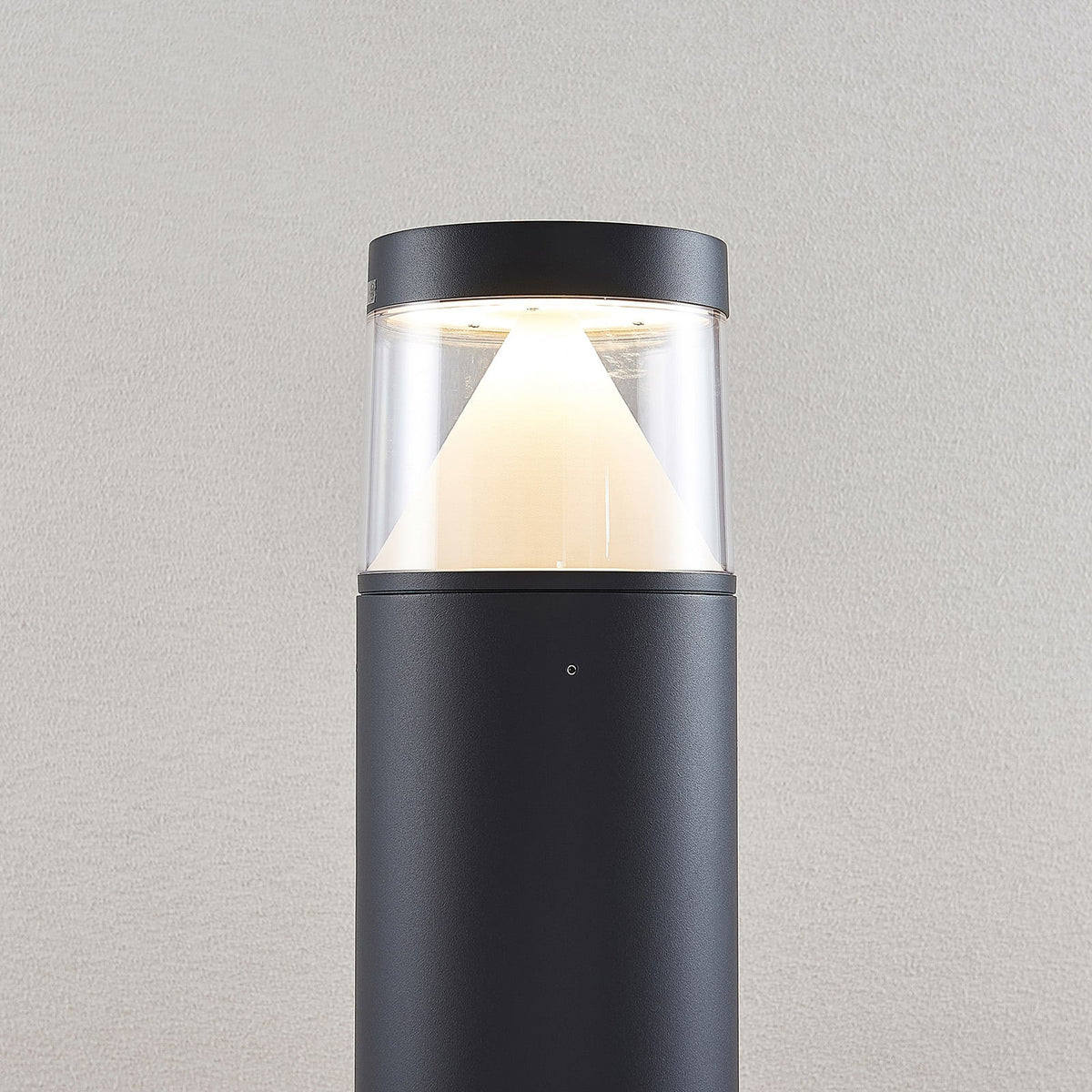 Close view of the Darjo Tall Bollard Light head showing the conical reflector behind clear glazing