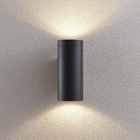 Tovi wall light lit at night showing the twin beam pattern on the wall