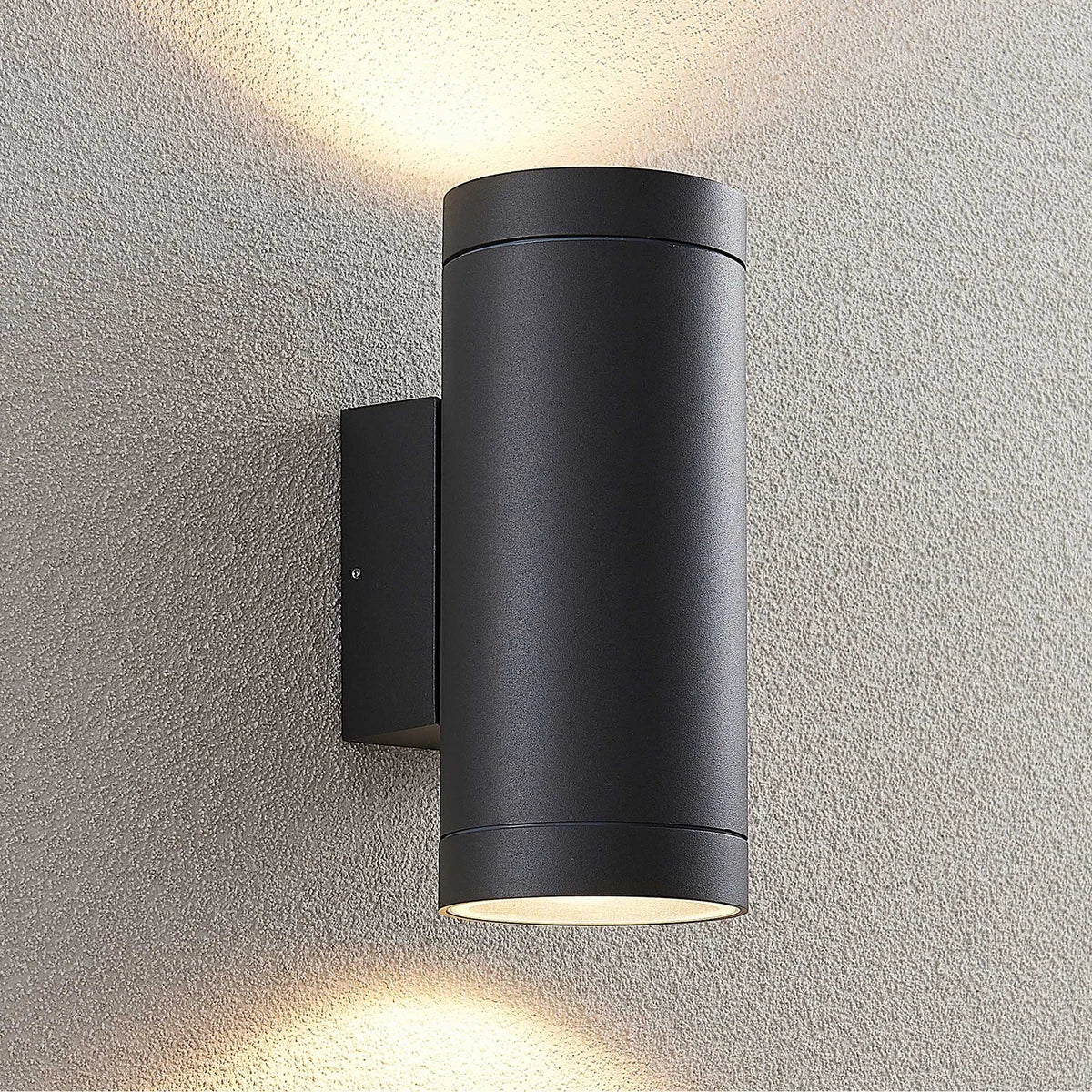 Tovi outdoor wall light mounted on a rendered wall casting light up and down