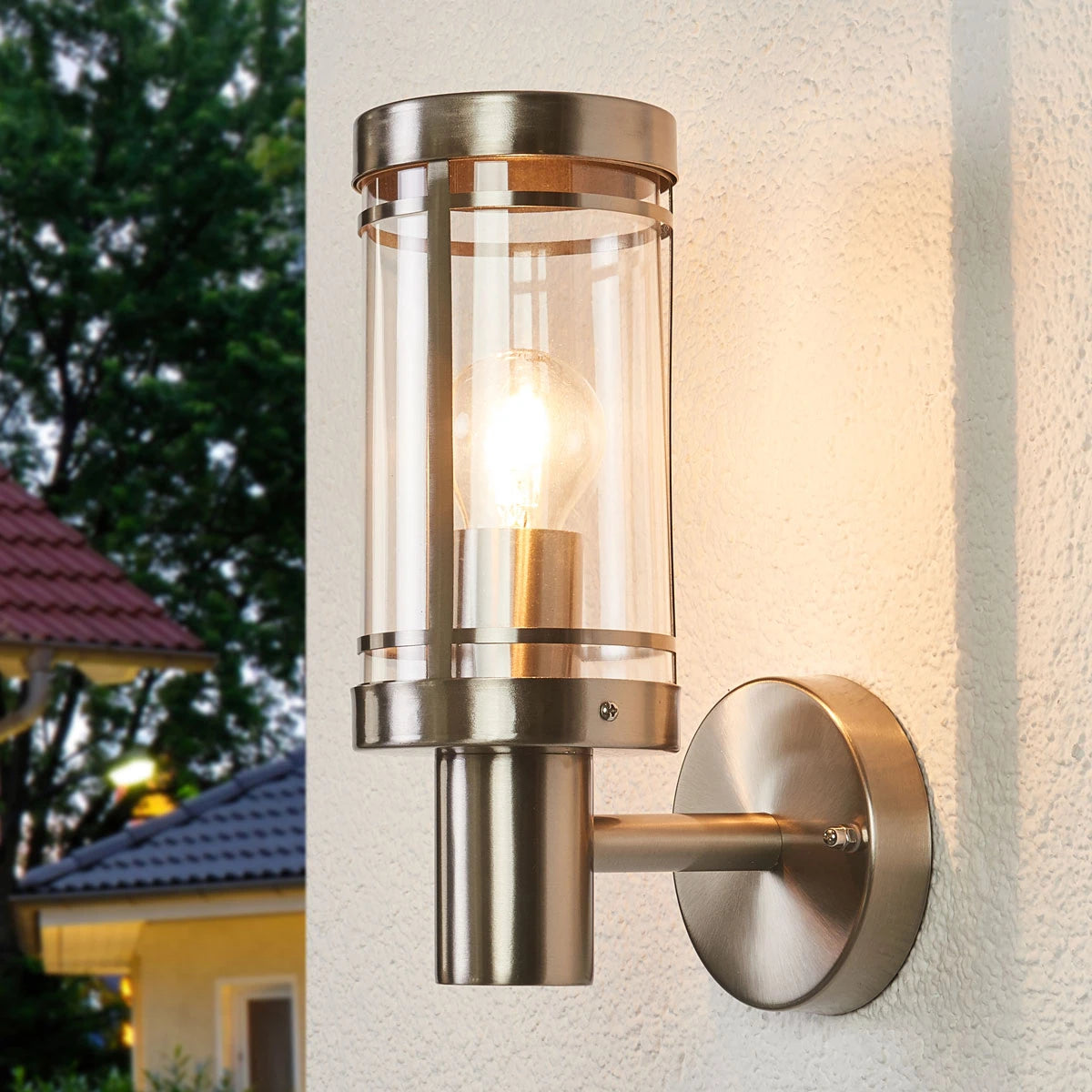 Davo outdoor wall light lit on a house wall at dusk