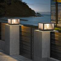 Sentry square outdoor pillar lights on concrete gate posts coastal garden at dusk