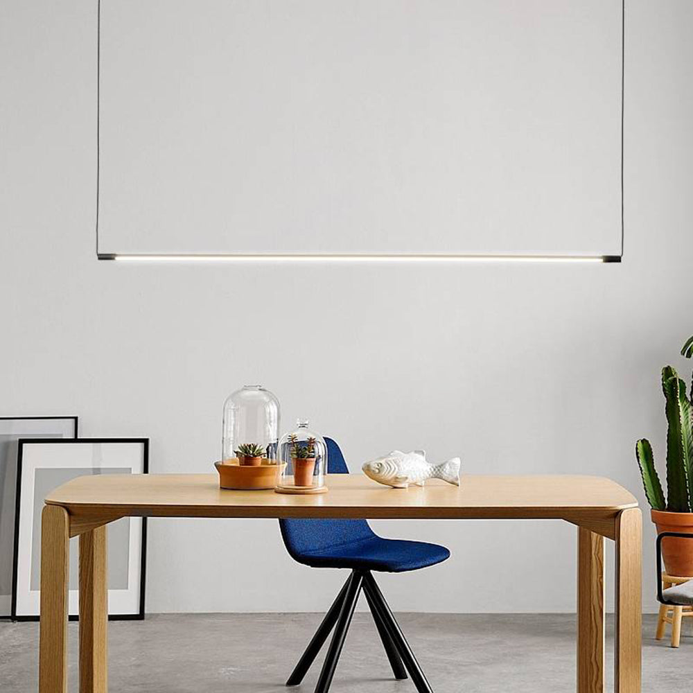 Zyno Linear Pendant Light lit above a light oak desk and chair