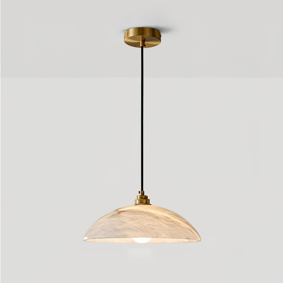 Full drop of the Delo pendant showing the brass ceiling canopy and black fabric cord