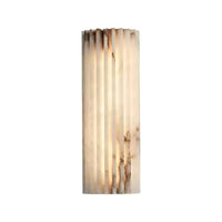 Alcaro alabaster wall light switched on, showing the warm glow through the ribbed stone panel