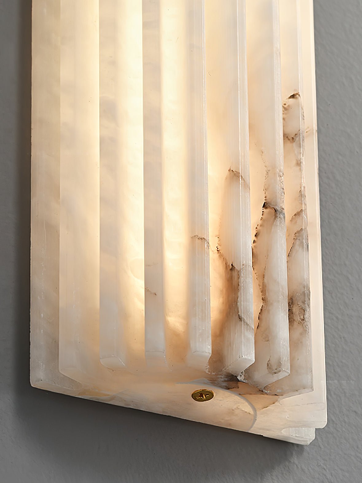 Close detail of the Alcaro alabaster wall light showing the natural stone veining and brass fixing