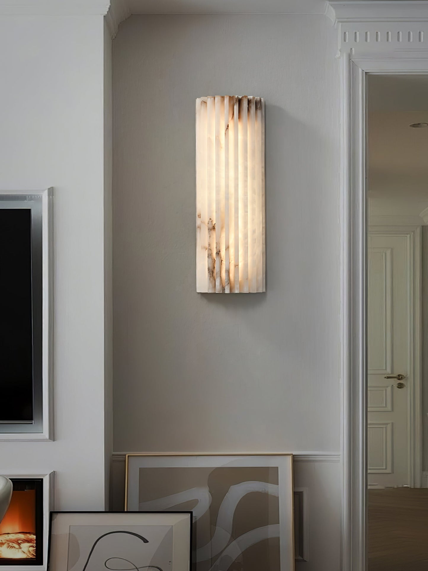 Alcaro alabaster wall light lighting a hallway wall beside a panelled doorway