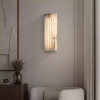 Alcaro alabaster wall light on a neutral living room wall above a boucle armchair
