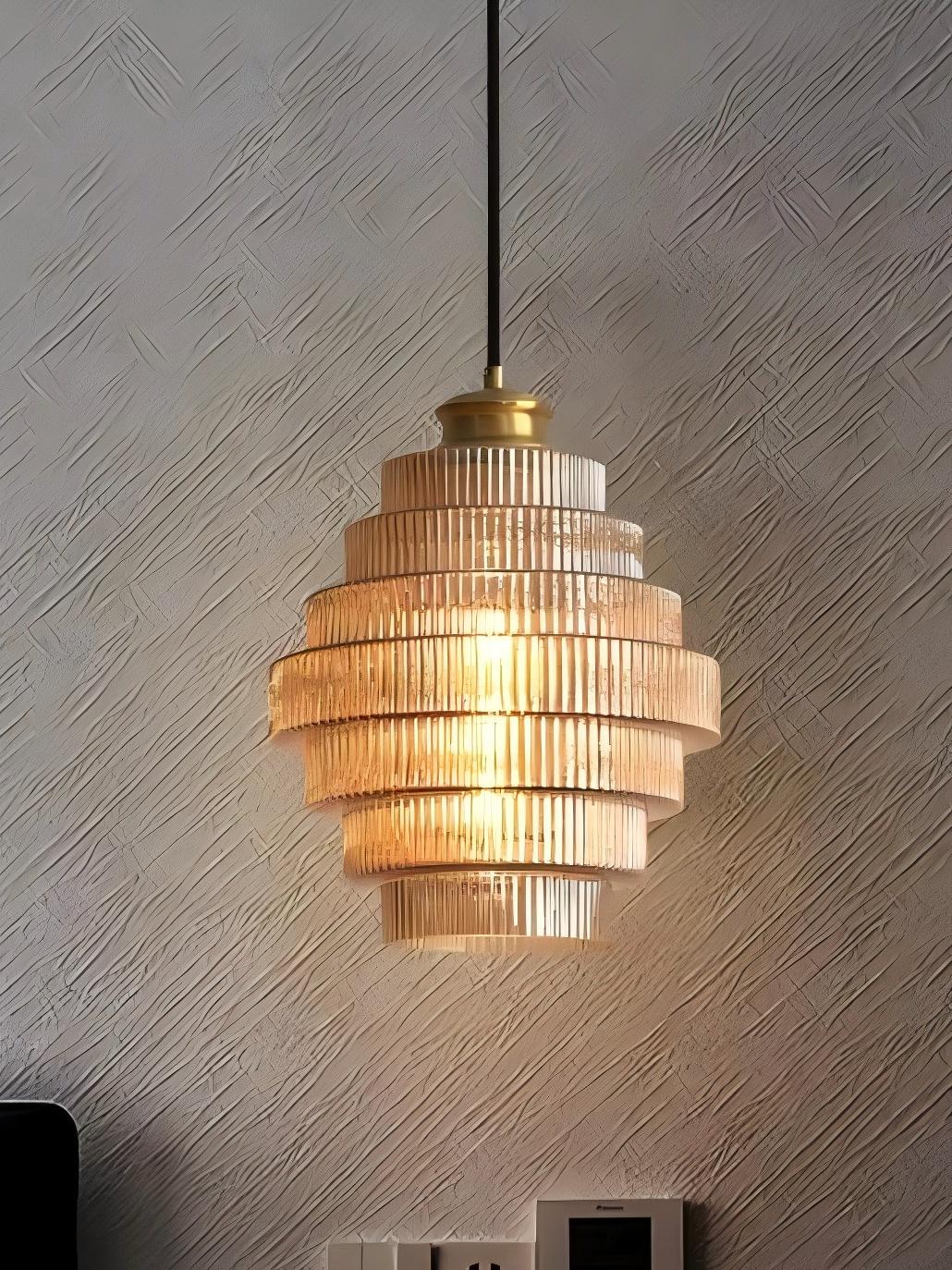 Idra amber glass pendant light lit against a textured plaster wall