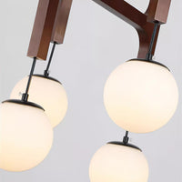 Close-up of the opal glass globes and walnut timber arms on the Zolven chandelier