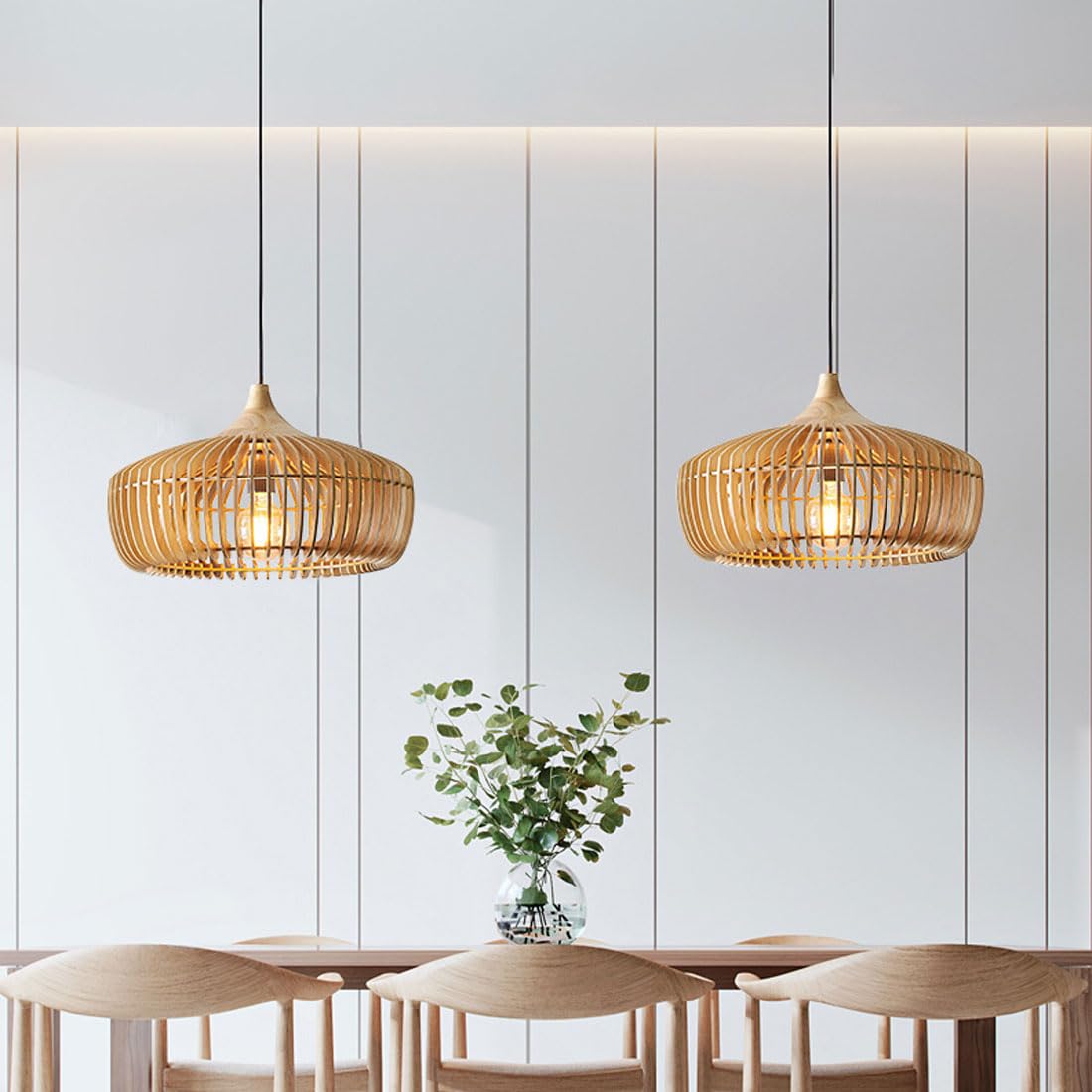 Two Muno natural wood pendant lights hanging over a dining table in a bright panelled room