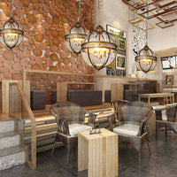 Edvo Retro Globe Pendant Lights hung in a row above a long timber table