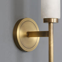 Close-up of the round brass backplate and flat arm on the Jerno wall light