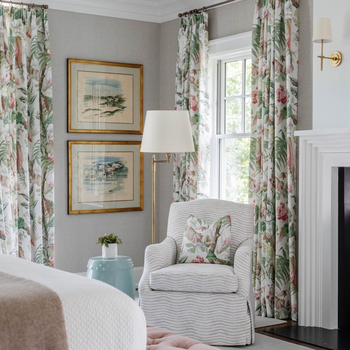 Thedo brass wall light in a bedroom beside a fireplace and armchair