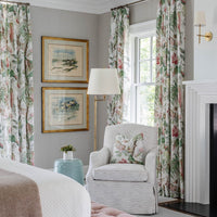 Thedo brass wall light in a bedroom beside a fireplace and armchair