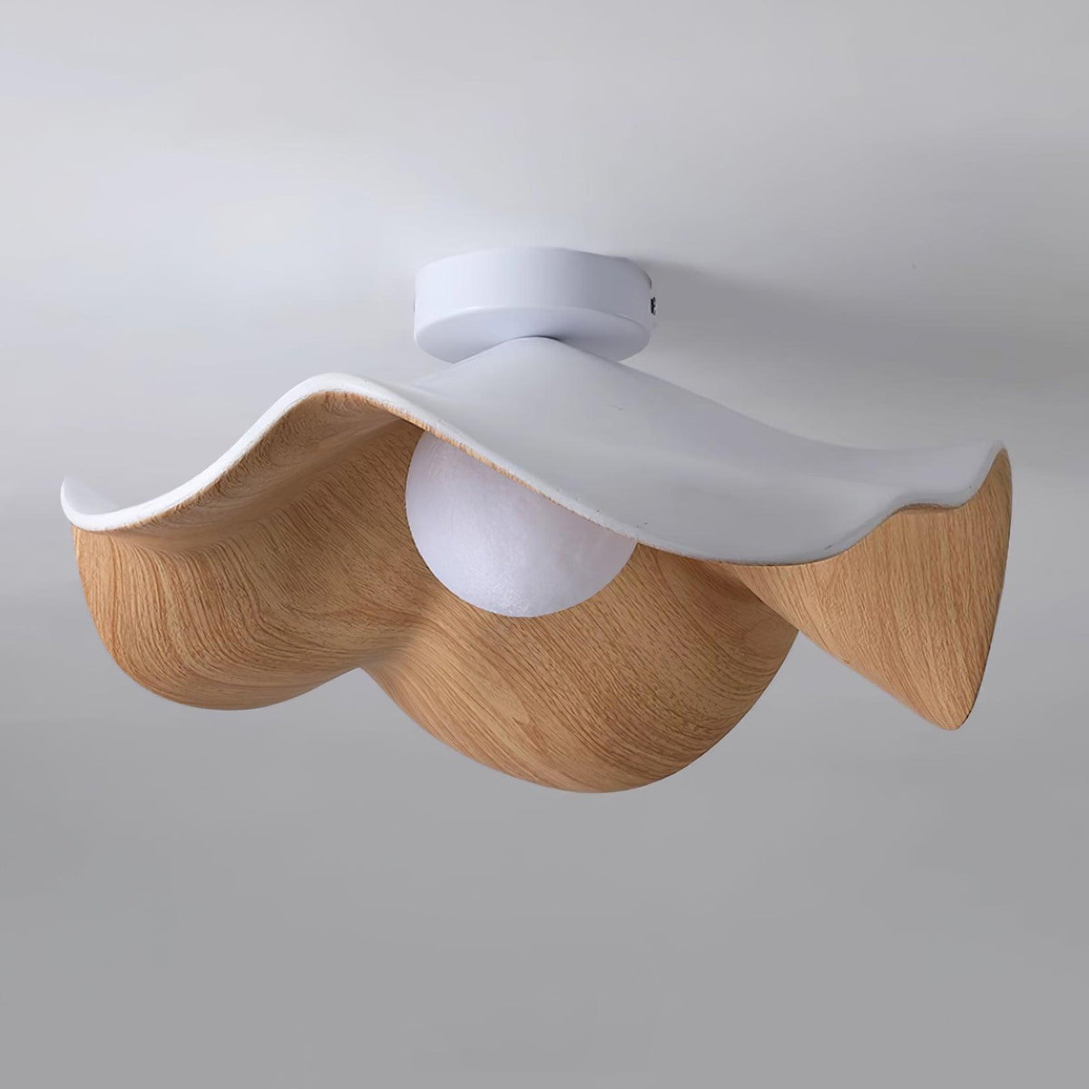 Tamsi ceiling light fitted flush to a white ceiling, showing the four wave petal rim from below