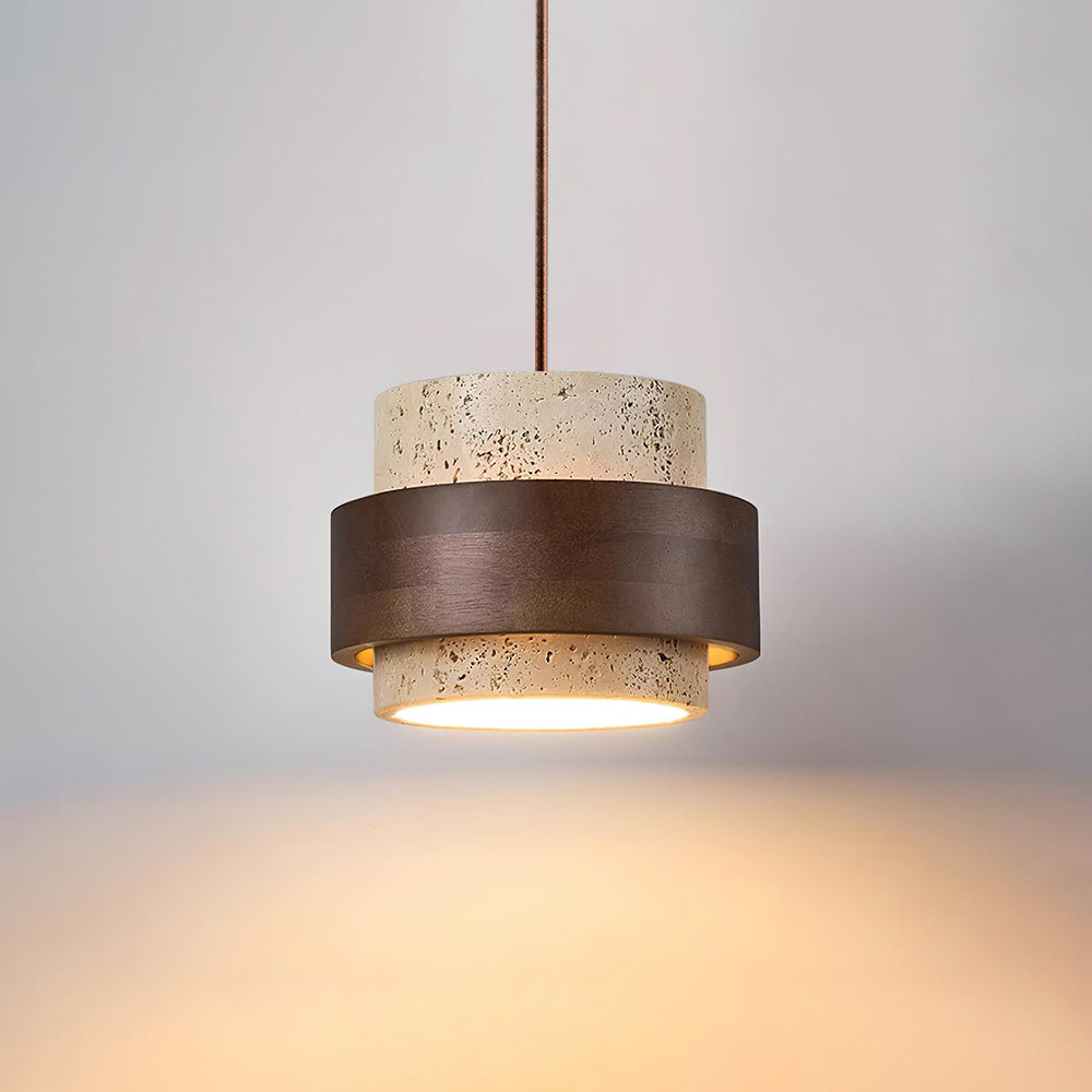 Petra travertine pendant light lit, showing the warm glow through the open base