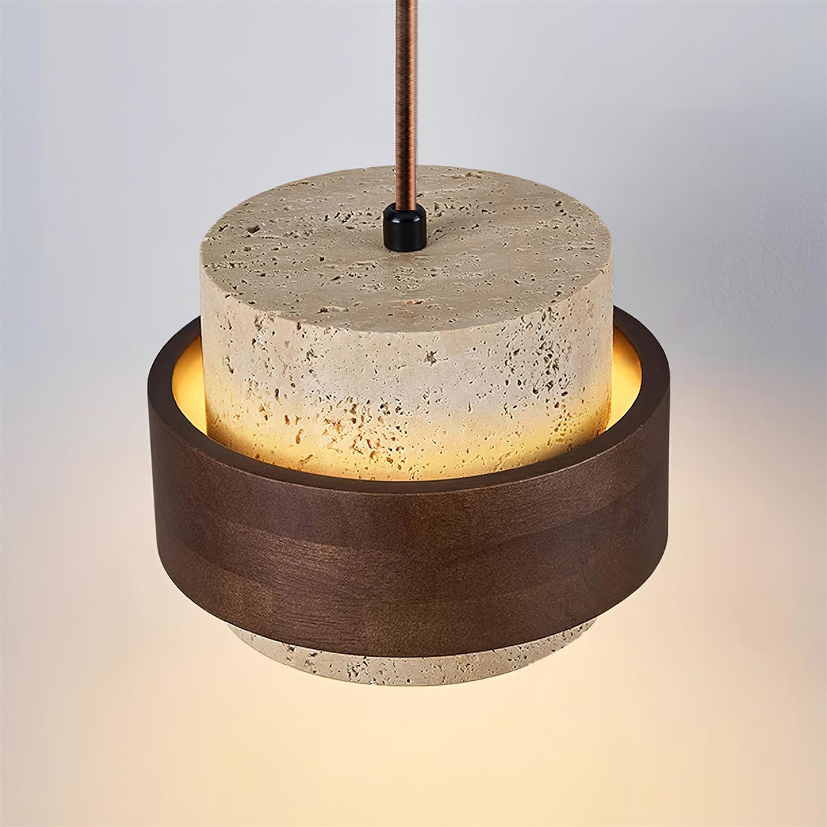 Close up of the pitted travertine stone and walnut wood band on the Petra pendant light