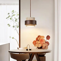 Petra travertine pendant light hanging above a round dining table in a bright corner