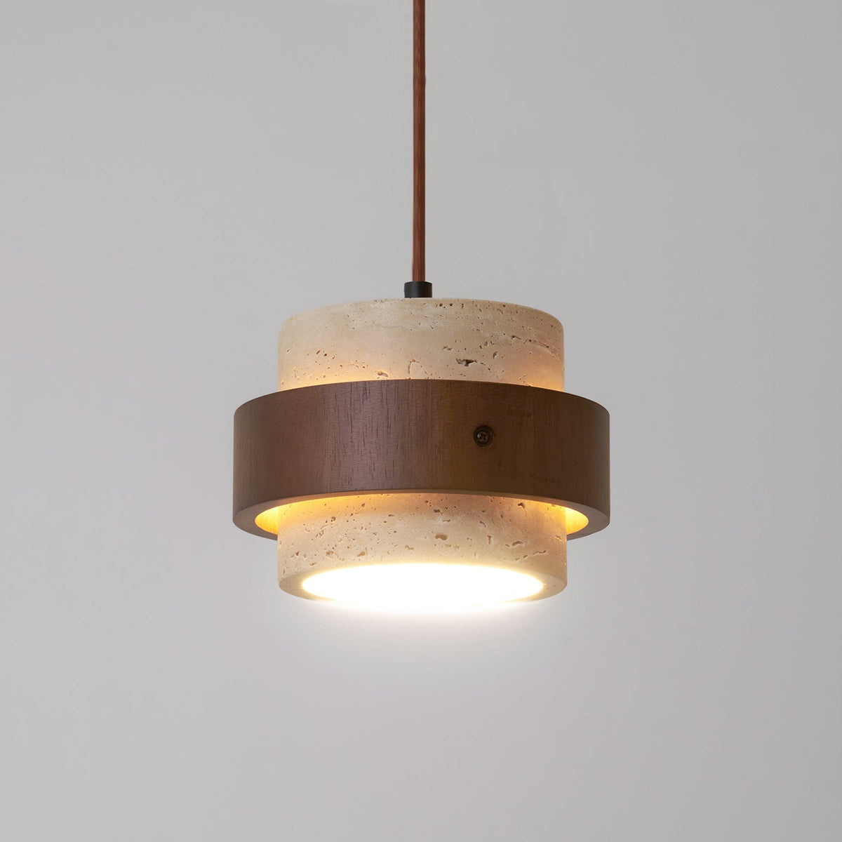Close view of the Cavora travertine shade and walnut band with the diffuser lit