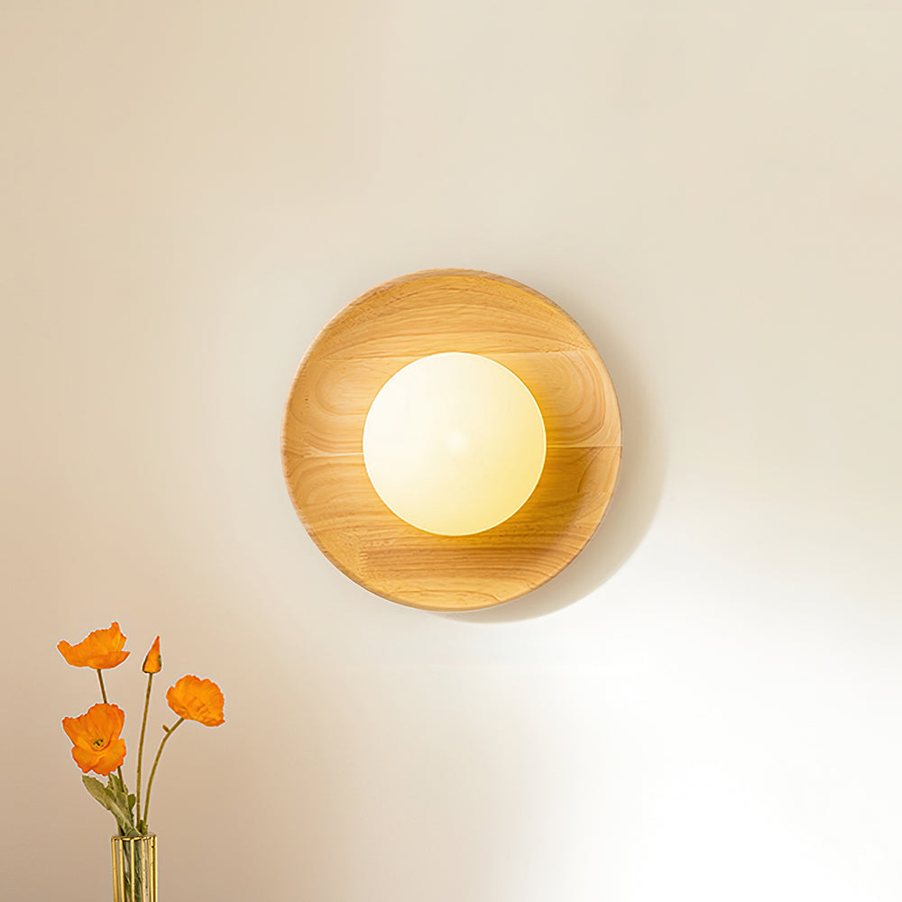 Tamso wood and opal glass wall light seen straight on with the lamp switched on