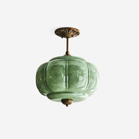 Eldo green glass ceiling light with a gold ceiling plate and matching finial on a plain white background