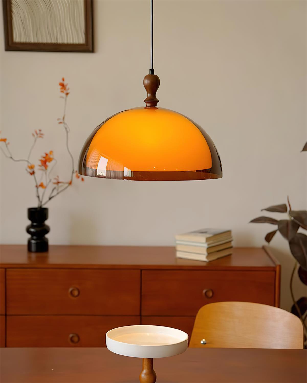 Pomera pendant hanging above a wooden sideboard in a warm living room