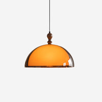 Pomera amber acrylic dome pendant light on a plain background with a turned walnut finial