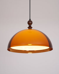 Pomera pendant lit against a plain background showing the honey tone of the amber acrylic dome