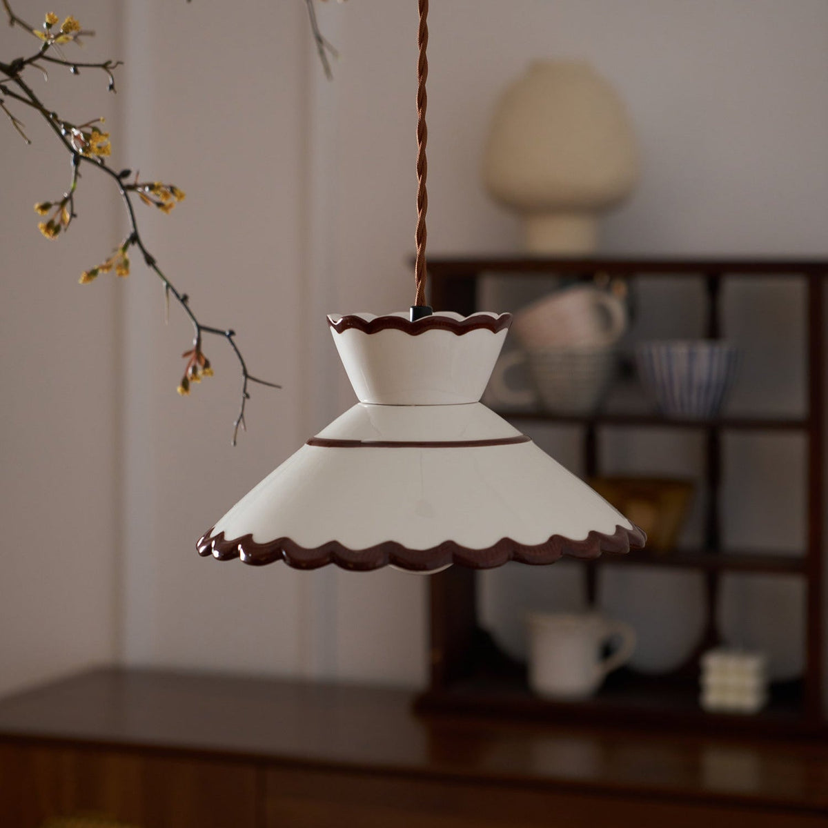 Wenna pendant light above a kitchen shelf holding cups and bowls