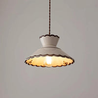 Wenna ceramic pendant light switched on against a plain pale wall