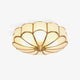 Ulina petal glass ceiling light on a plain white background, frosted glass panels in a brass finish frame