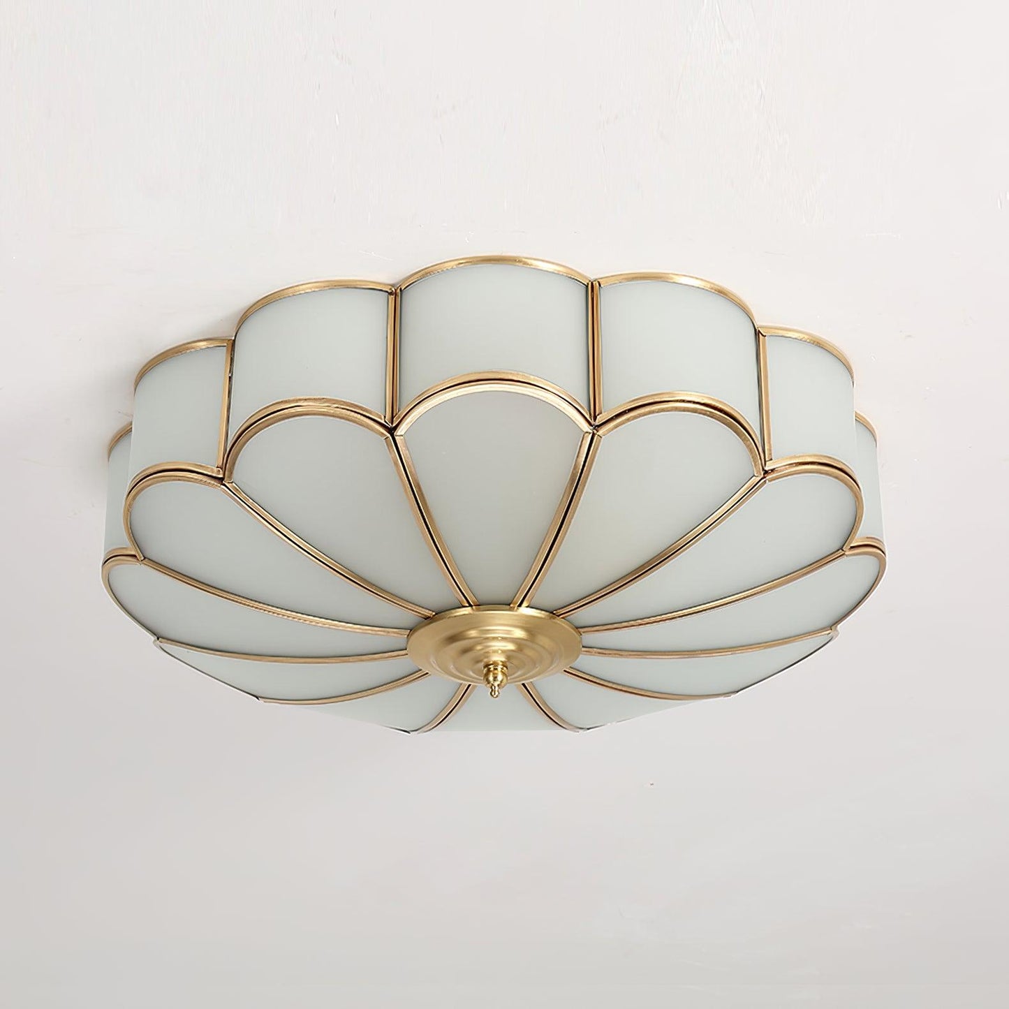 Ulina flush mount ceiling light fitted to a white ceiling in daylight, showing the brass finish frame