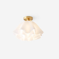 Ondra petal ceiling light lit against a plain background, showing the layered white acrylic folds glowing