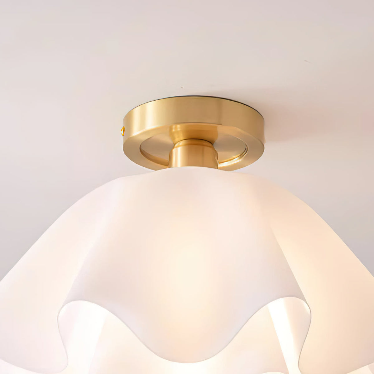 Close view of the brass canopy and the layered acrylic petals of the Ondra ceiling light