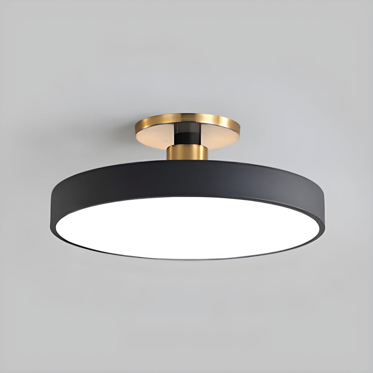 Nelo Round Flush Mount Ceiling Light – matte black drum with brass canopy on grey background