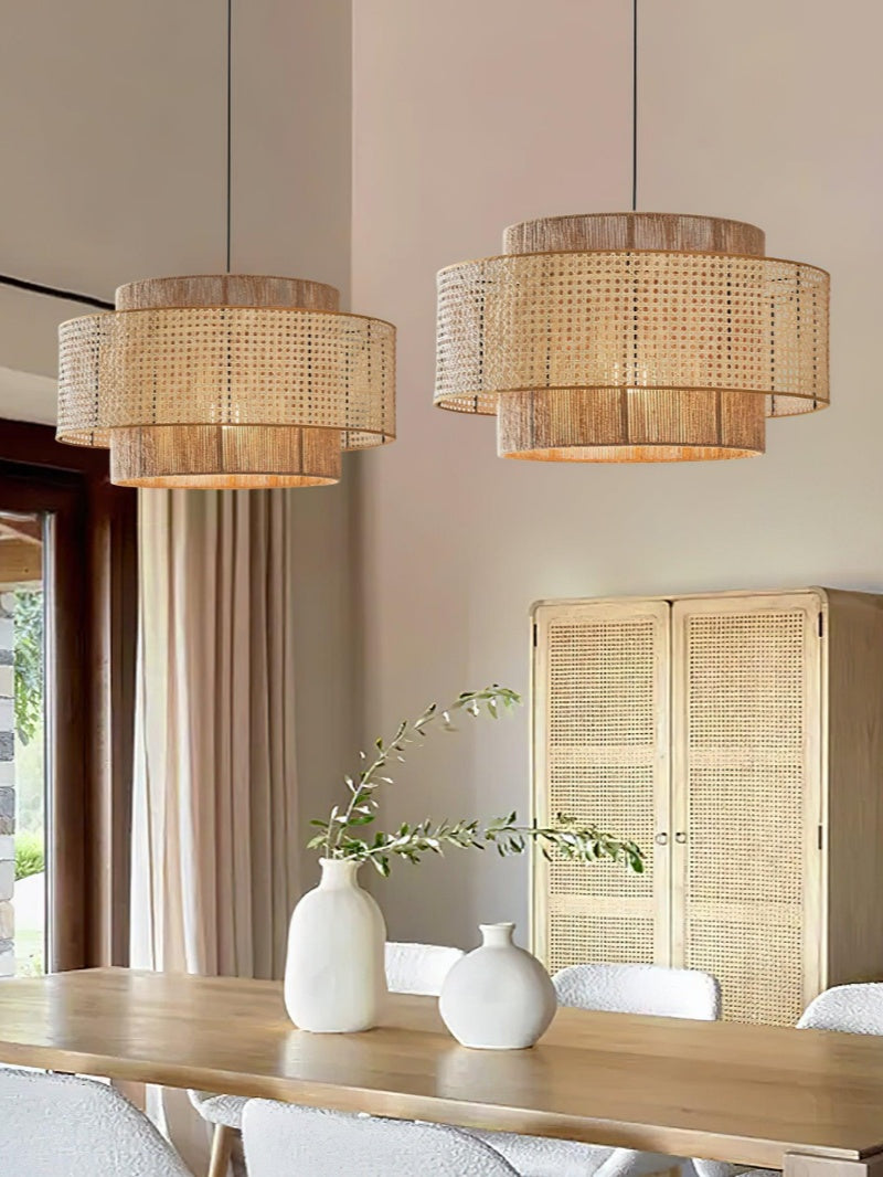 Pair of rattan drum pendant lights above a wooden dining table