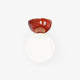 Vellona Petite Ceiling Light on a plain white background, glossy red half-dome above a glowing opal glass sphere