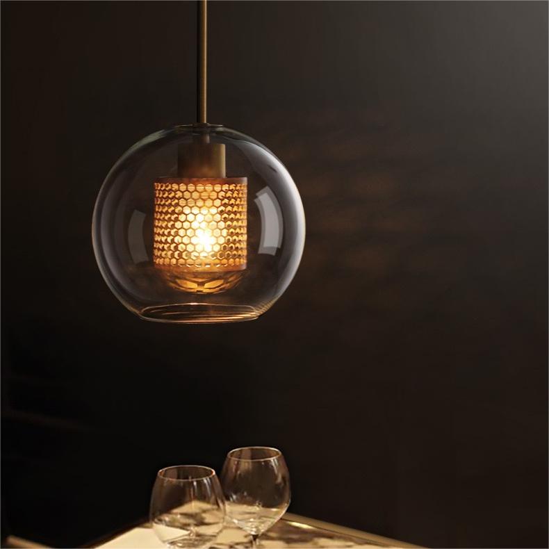 Hesso pendant light glowing warm above a dining table set with glassware