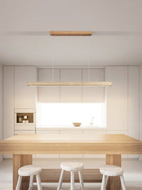 Sonvel linear pendant hanging over a pale wood kitchen island