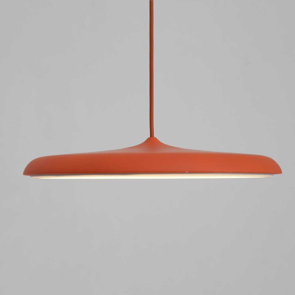 Side profile of the Tarvo orange disc pendant light showing the 6.5cm slim shade depth
