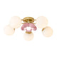 Peona pink petal ceiling light on a plain white background, five opal glass globes on gold arms around a pink flower centre