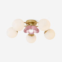 Peona five light flush mount ceiling light seen from the side, gold arms and opal white glass globes