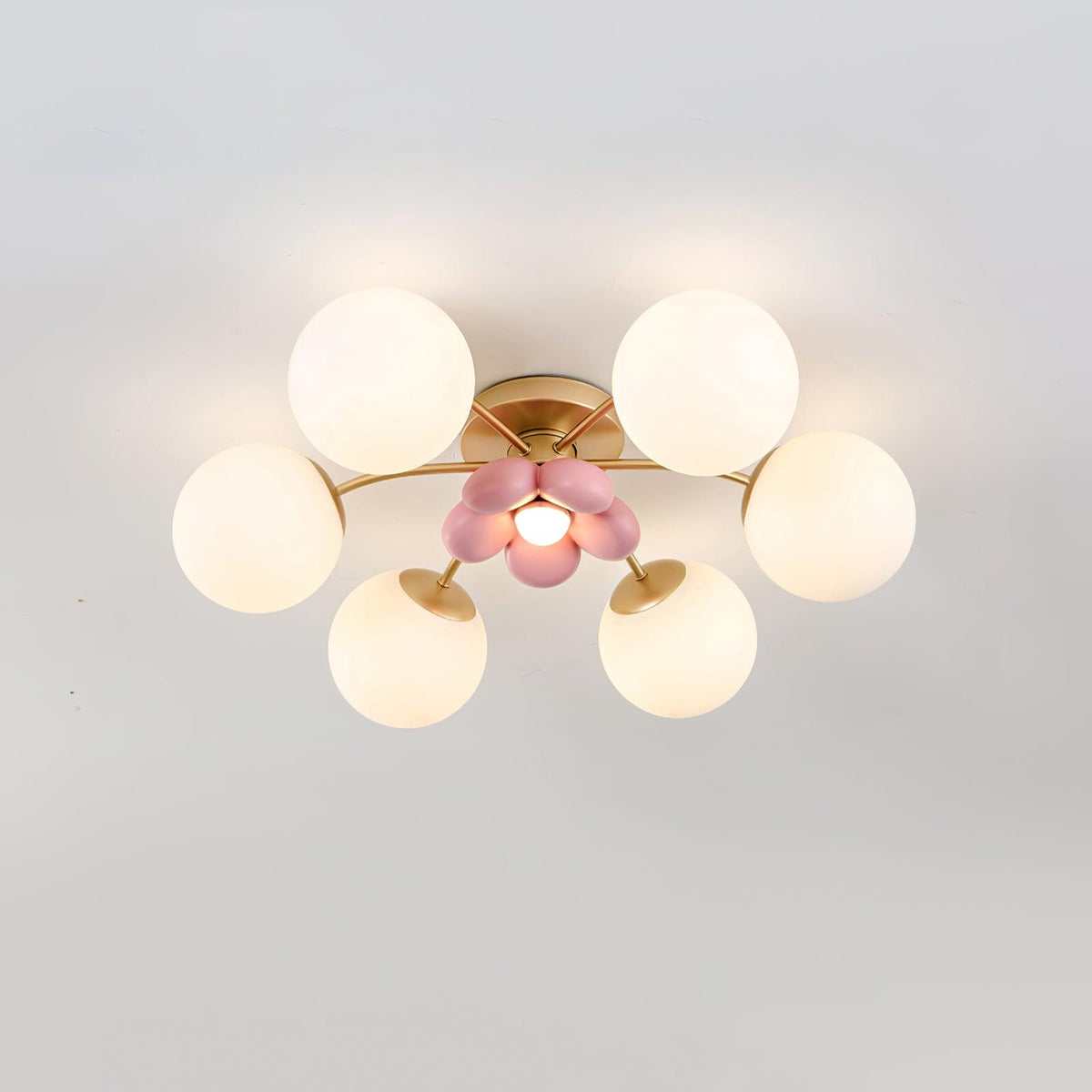 Peona pink petal ceiling light switched on, warm glow across the opal glass globes
