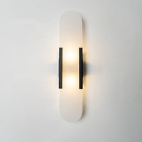 Veola wall light illuminated, with light spilling above and below the alabaster panel